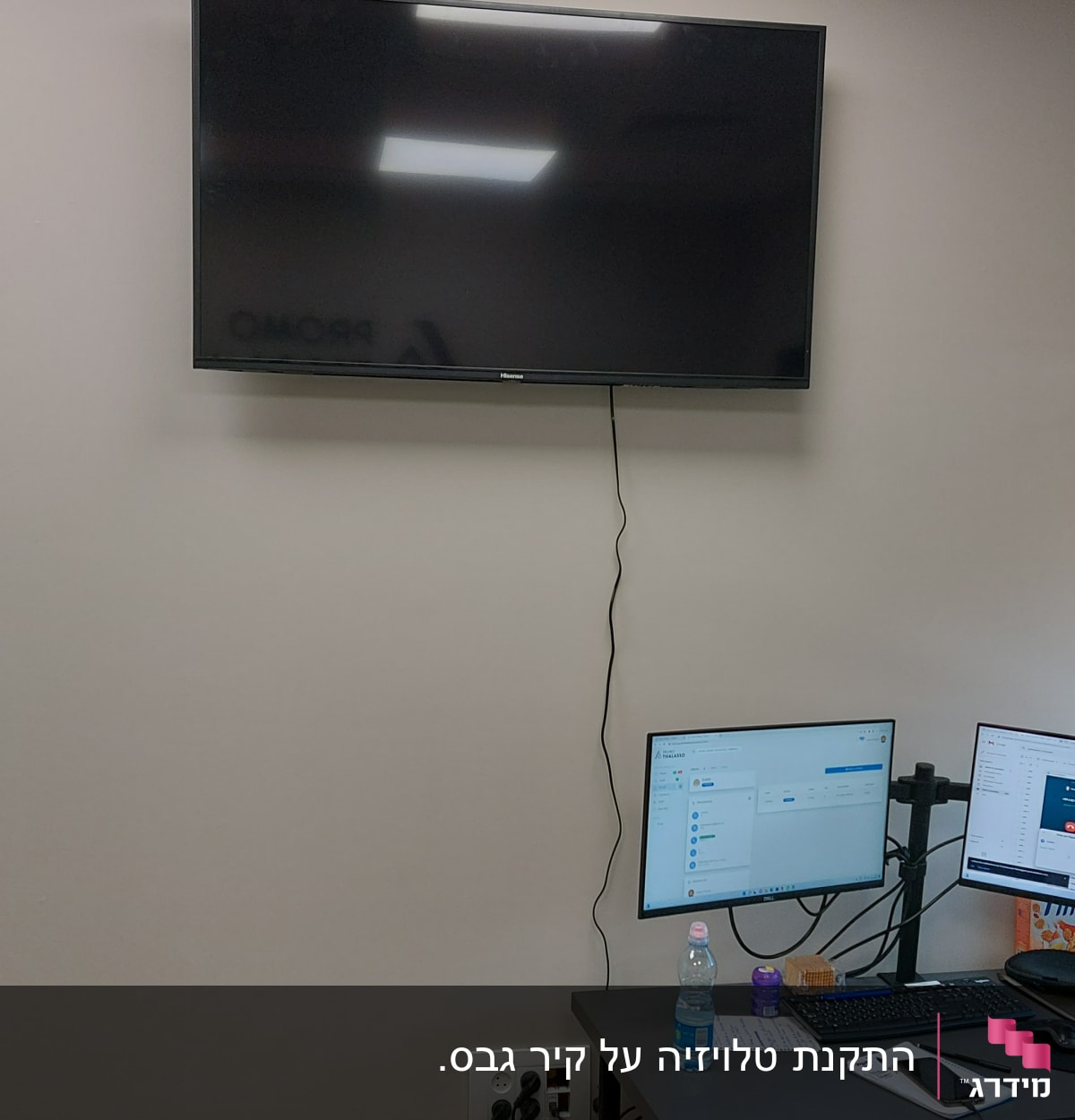 טלוויזיה תלויה על הקיר עם כבל חשמל מחובר